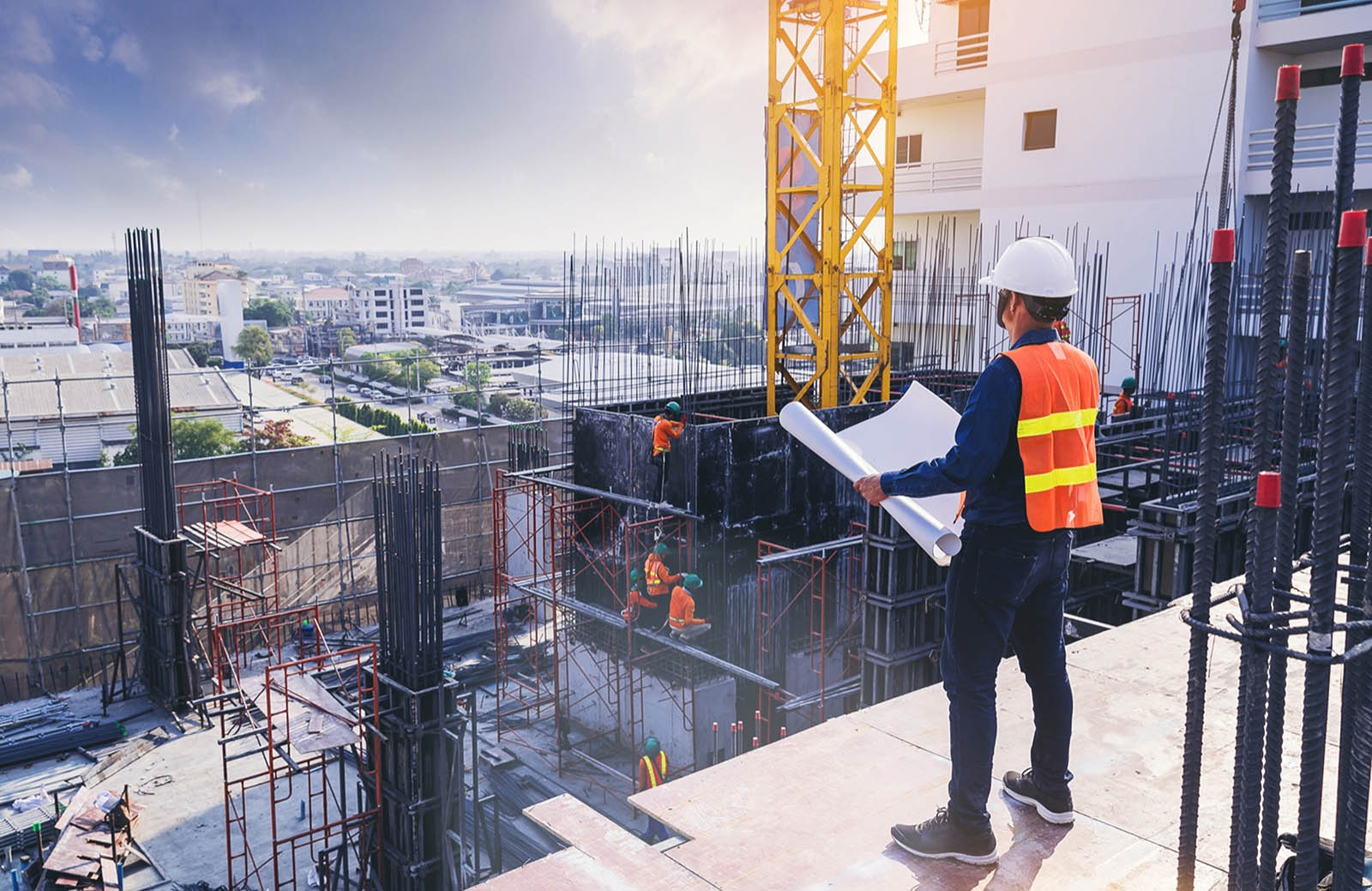 Person mit Helm überblickt eine Baustelle